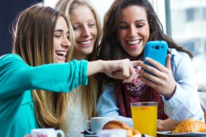 A group of woman friends having fun with smartphones
